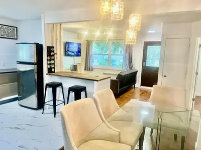 a kitchen and living room with a glass table and chairs at Escapade Marie-Isabelle in Montréal
