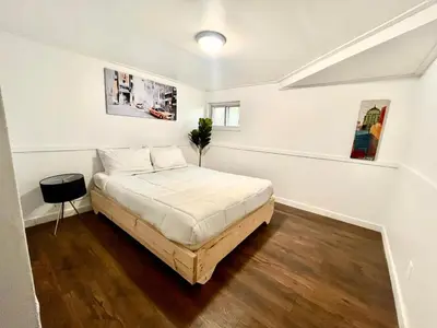 a bedroom with a bed in a white room at Escapade Marie-Isabelle in Montréal