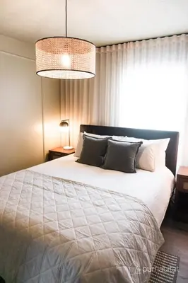 a bedroom with a large white bed and a window at Studio 21 charme et confort au coeur de Magog in Magog-Orford