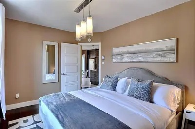 a bedroom with a large bed with blue and white pillows at Sacha's Home Away in Quiet Montreal in Montréal