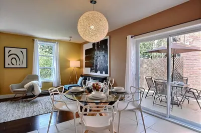 a dining room and living room with a table and chairs at Sacha's Home Away in Quiet Montreal in Montréal