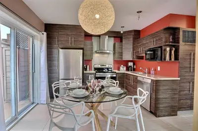 a kitchen with a table and chairs in a kitchen at Sacha's Home Away in Quiet Montreal in Montréal