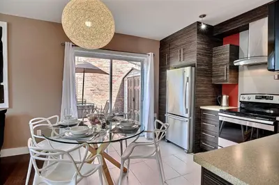 a kitchen with a table and chairs in a kitchen at Sacha's Home Away in Quiet Montreal in Montréal
