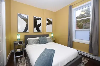 a bedroom with a white bed and two windows at Ground Floor Loft Style Luxury Executive Flat in Montréal