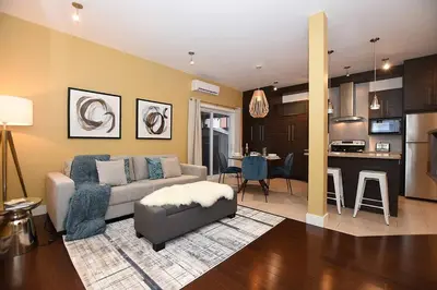a living room with a couch and a kitchen at Ground Floor Loft Style Luxury Executive Flat in Montréal