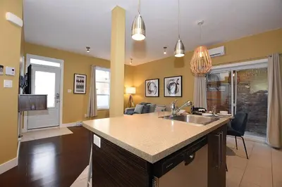 a kitchen with a sink and a living room at Ground Floor Loft Style Luxury Executive Flat in Montréal
