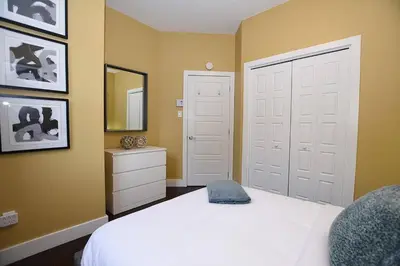 a bedroom with a white bed with a hat on it at Ground Floor Loft Style Luxury Executive Flat in Montréal
