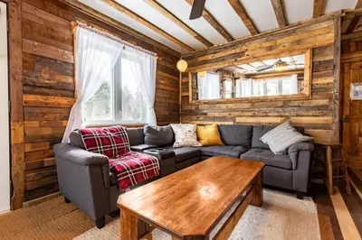 a living room with a couch and a table at Chalet Le Mignon Nature Escape & Comfort in Saint Ambroise de Kildare