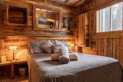 a bedroom with a bed in a log cabin at Chalet Le Mignon Nature Escape & Comfort in Saint Ambroise de Kildare