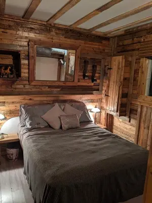 a bedroom with a bed in a room with wooden walls at Chalet Le Mignon Nature Escape & Comfort in Saint Ambroise de Kildare