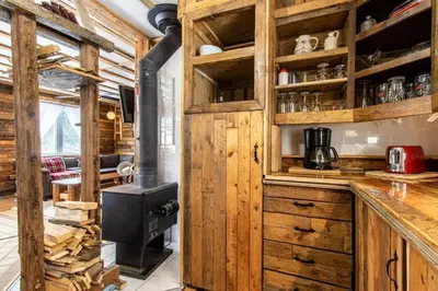 a kitchen with wooden cabinets and a stove at Chalet Le Mignon Nature Escape & Comfort in Saint Ambroise de Kildare