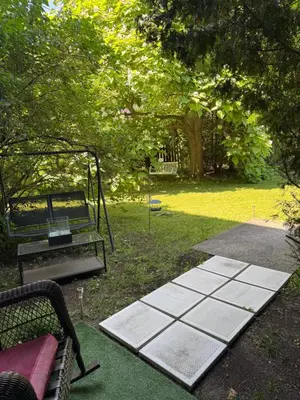 a park with a swing and a bench and trees at la voyageuse in Longueuil