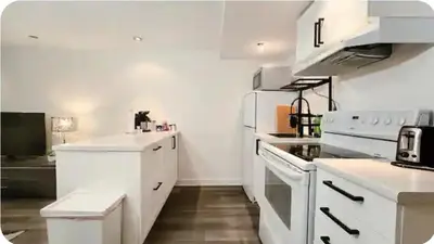 a kitchen with white counters and a white appliances at Boho style Private rooms in a shared three rooms apartment in Montréal