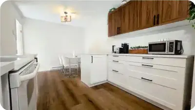 a kitchen with white cabinets and a microwave at Boho style Private rooms in a shared three rooms apartment in Montréal