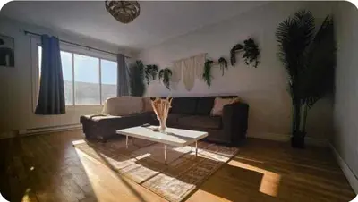 a living room with a couch and a coffee table at Boho style Private rooms in a shared three rooms apartment in Montréal