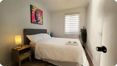 a bedroom with a white bed and a window at Boho style Private rooms in a shared three rooms apartment in Montréal