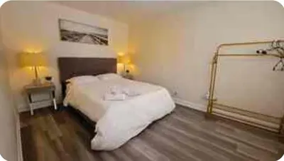 a bedroom with a large white bed and two lamps at Boho style Private rooms in a shared three rooms apartment in Montréal