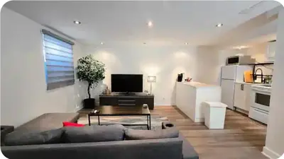 a living room with a couch and a table and a kitchen at Boho style Private rooms in a shared three rooms apartment in Montréal