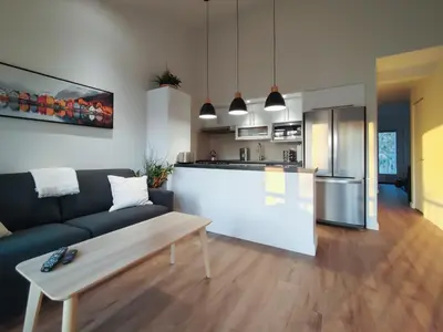 a living room with a couch and a kitchen at Chalet Tranquillité Orford in Magog-Orford