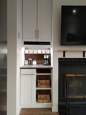 a white kitchen with a fireplace and a tv at Chalet Tranquillité Orford in Magog-Orford