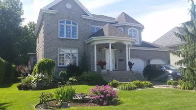 a house with a car parked in front of it at Chez Carole - Établissement d'hébergement de résidence principale sur la Rive-Sud de Montréal in Mercier