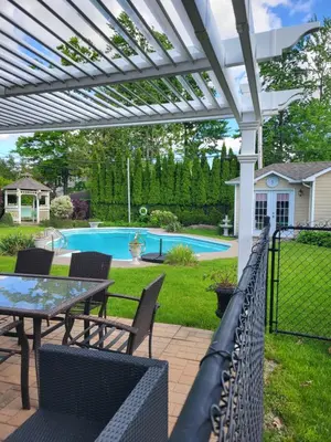 a patio with a table and chairs and a pool at Chez Carole - Établissement d'hébergement de résidence principale sur la Rive-Sud de Montréal in Mercier