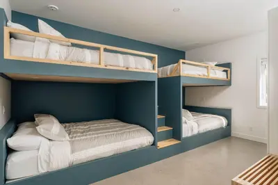two bunk beds in a room with blue walls at Chalet a Samia - Spa, luxury, Jay Peak view in Mansonville