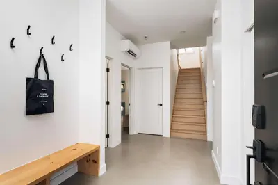 a hallway with white walls and a wooden bench at Chalet a Samia - Spa, luxury, Jay Peak view in Mansonville