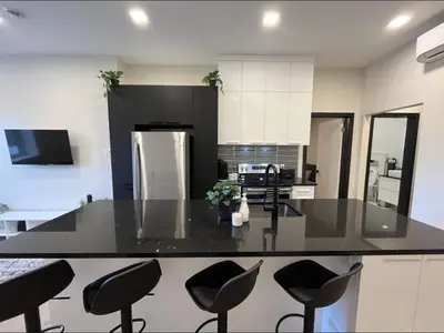 a kitchen with a black counter and chairs in it at Luxury apartment in Mont Royal in Montréal