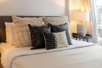 a bed with many pillows on top of it at Elegant 1BR Retreat and Chic Stay in Old Port in Montréal