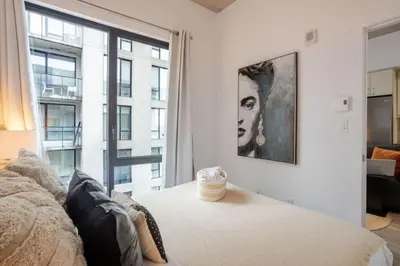 a bedroom with a picture of a woman on the wall at Elegant 1BR Retreat and Chic Stay in Old Port in Montréal