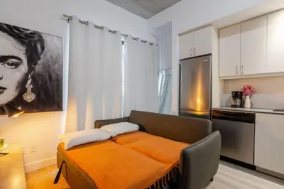 a kitchen with a bed in the middle of a room at Elegant 1BR Retreat and Chic Stay in Old Port in Montréal