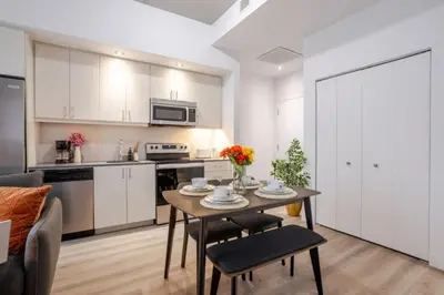 a kitchen and living room with a table and chairs at Elegant 1BR Retreat and Chic Stay in Old Port in Montréal