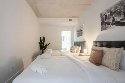 a large white bed in a room with a couch at Roomy 1BR Getaway MTL Old Port in Montréal