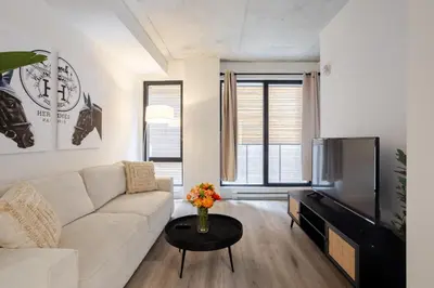 a living room with a couch and a tv at Roomy 1BR Getaway MTL Old Port in Montréal