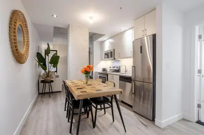 a kitchen with a table with chairs and a refrigerator at Roomy 1BR Getaway MTL Old Port in Montréal