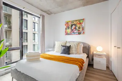 a bedroom with a bed and a large window at Sophisticated 1BR Escape , Charm in Old Port in Montréal