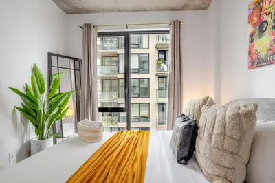 a living room with a couch and a large window at Sophisticated 1BR Escape , Charm in Old Port in Montréal