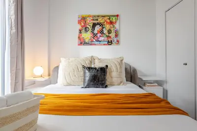 a bedroom with a bed with an orange blanket on it at Sophisticated 1BR Escape , Charm in Old Port in Montréal