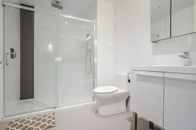 a white bathroom with a shower and a toilet at Sophisticated 1BR Escape , Charm in Old Port in Montréal