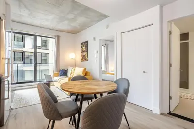 a living room with a table and chairs at Sophisticated 1BR Escape , Charm in Old Port in Montréal