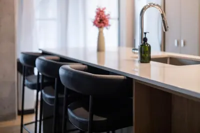 a kitchen counter with a sink and a row of bar stools at Exclusive Sanctuary Elegance Meets Comfort in Montréal