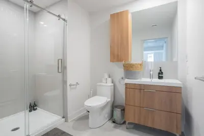 a white bathroom with a toilet and a shower at Exclusive Sanctuary Elegance Meets Comfort in Montréal