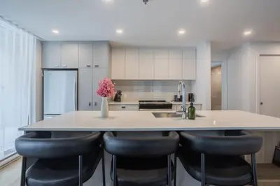 a kitchen with a large island with black bar stools at Exclusive Sanctuary Elegance Meets Comfort in Montréal