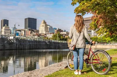 a woman standing next to a bike next to a river at Exclusive Sanctuary Elegance Meets Comfort in Montréal