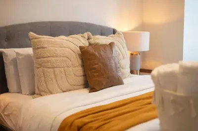 a bed with pillows and a blanket on it at Sleek 2BR in Heart of Downtown Montreal in Montréal