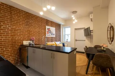 a kitchen with a sink and a brick wall at Sleek 2BR in Heart of Downtown Montreal in Montréal