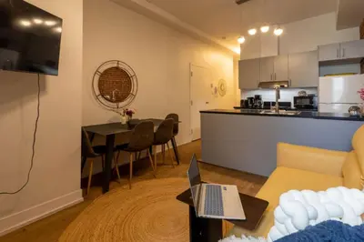 a living room with a couch and a table with a laptop at Sleek 2BR in Heart of Downtown Montreal in Montréal