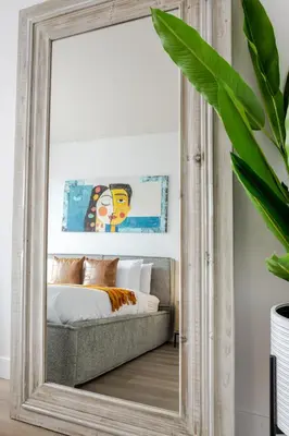 a large mirror in a bedroom with a bed at Modern Heritage Stay Upscale 2BR in Old Port in Montréal