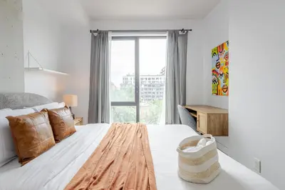 a bedroom with a large bed with a large window at Modern Heritage Stay Upscale 2BR in Old Port in Montréal